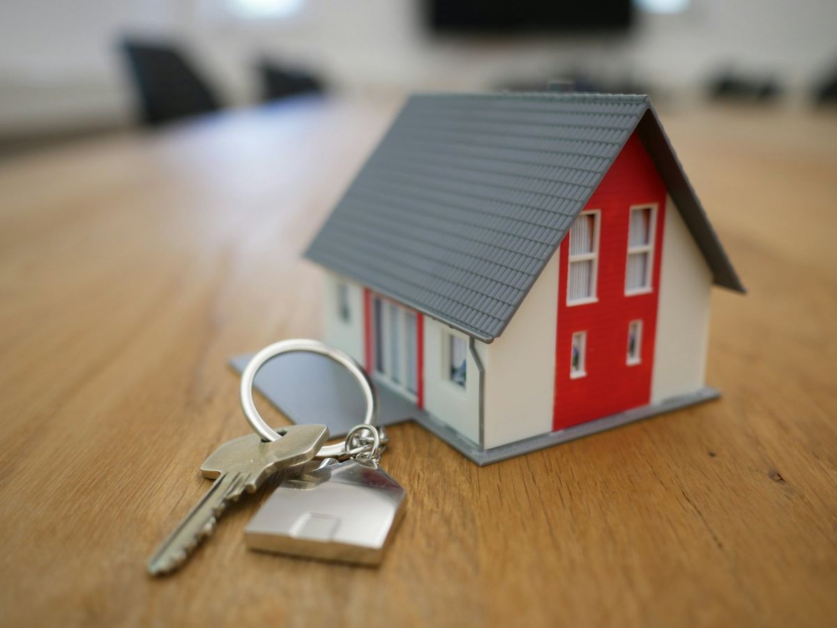 A model house and a set of keys resting on a table.